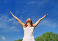 Woman celebrating under a blue sky