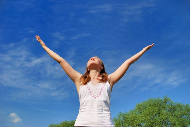 Woman celebrating under a blue sky