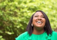 Smiling woman enjoying a sunny outdoor moment.